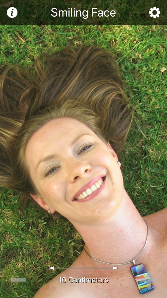 Cosmic Eye - Cosmic Eye app screenshot showing a smiling woman lying on grass at a 10 centimeter scale