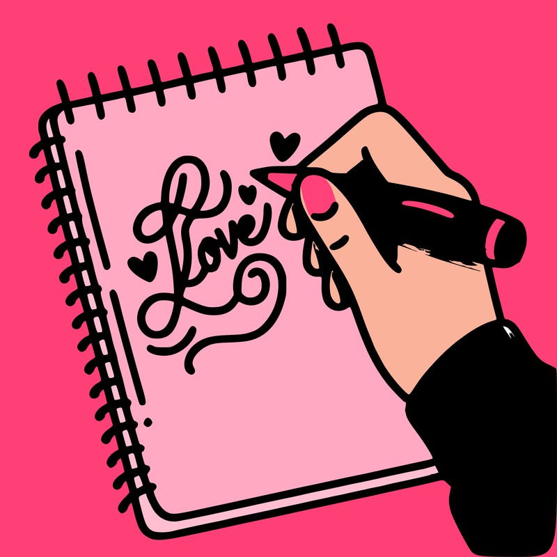 a hand writing “love” in calligraphy on a notebook