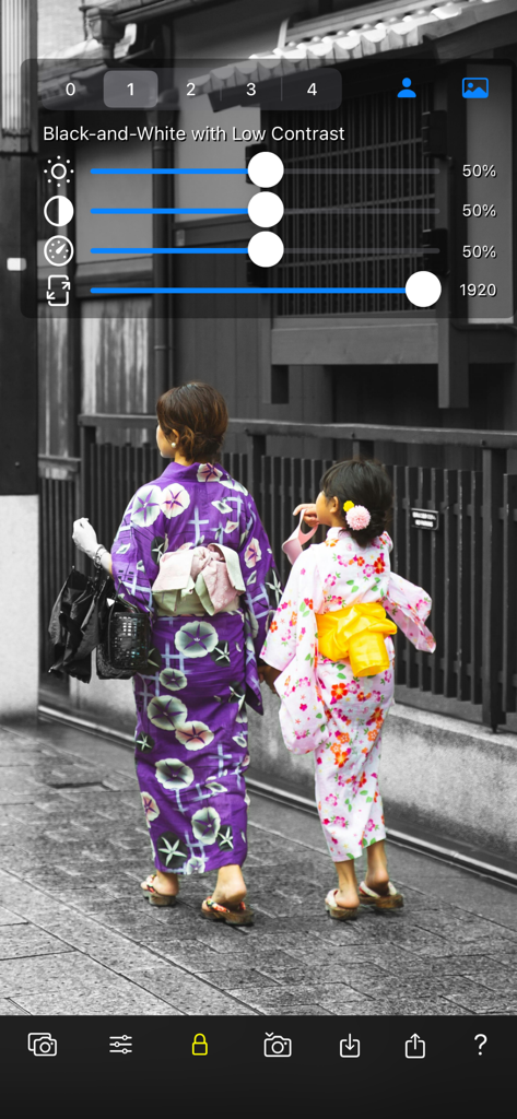 Color Focus Lens - Two people in colorful kimonos against a monochrome background in the Color Focus Lens app with adjustment sliders.