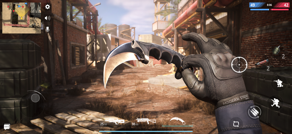 First-person view of a character holding a tactical karambit knife in a Modern Strike Online combat zone.