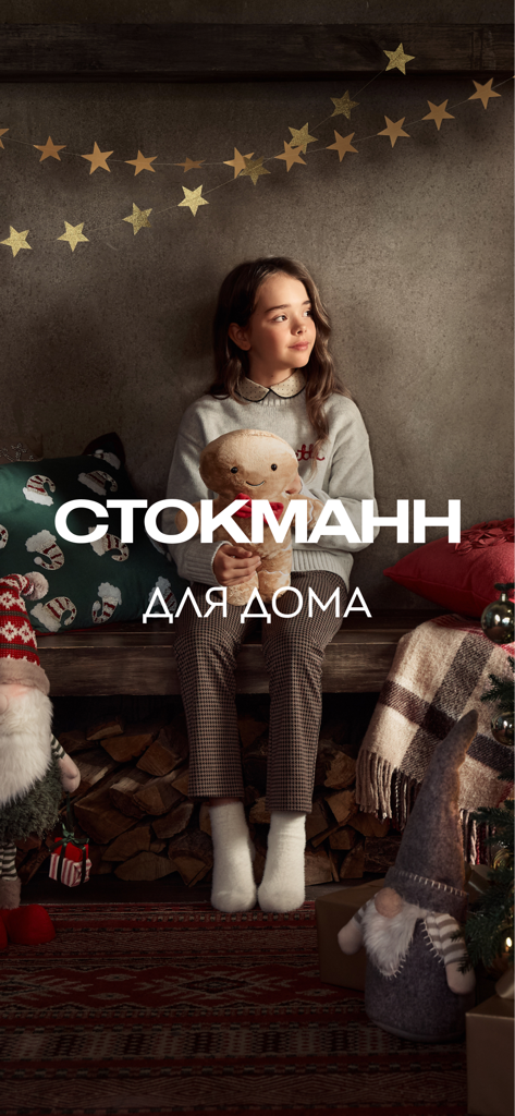 A young girl holding a gingerbread plush toy in a festive room representing Stockmann home collection