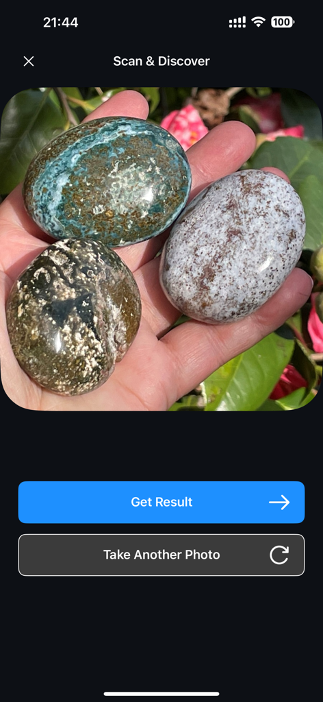 Rock Identifier: Stone Scan ID - User holding three polished stones in the Rock Identifier app scanning interface