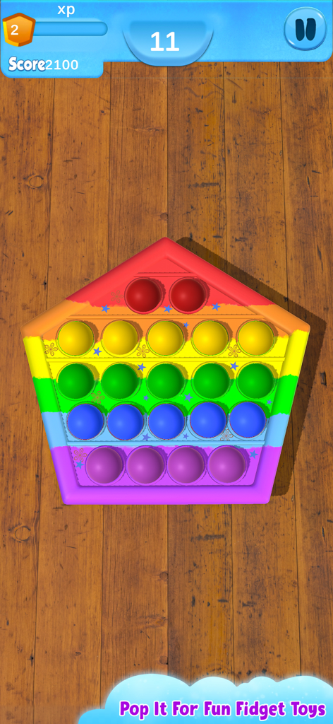 Fidget Toys 3D - Pop It Game - A rainbow pentagon shaped pop it fidget toy displayed on a wooden table surface.