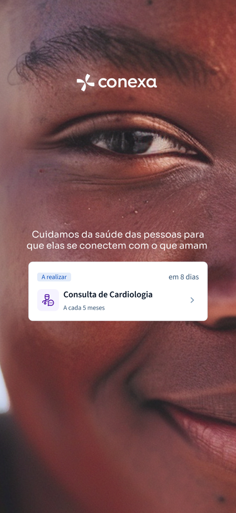 Conexa Saude app screen showing a scheduled cardiology consultation reminder over a person's face