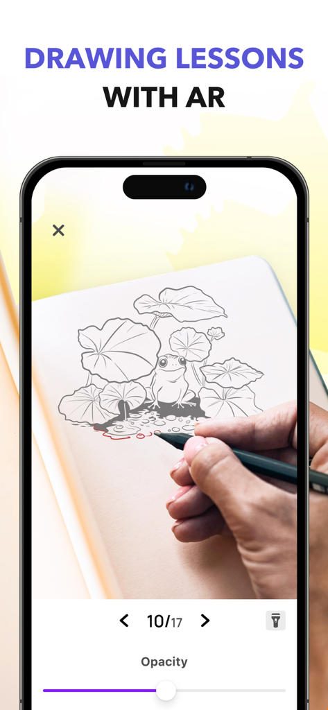 My Sketchbook - Masterclass - Smartphone screen showing an augmented reality drawing lesson for sketching a frog on physical paper