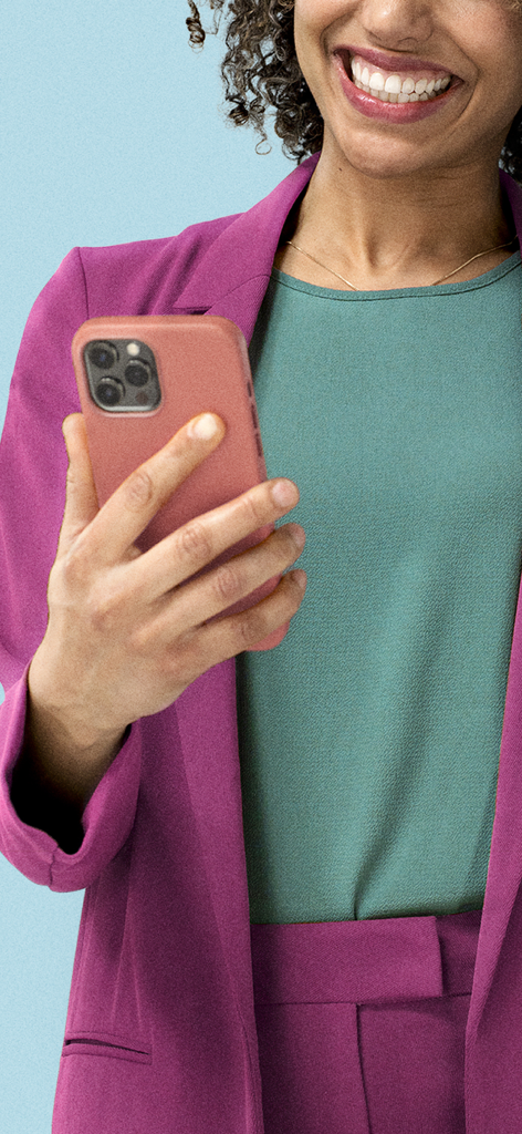 紫色のブレザーを着た笑顔の若いプロフェッショナルな女性がスマートフォンを持っています。