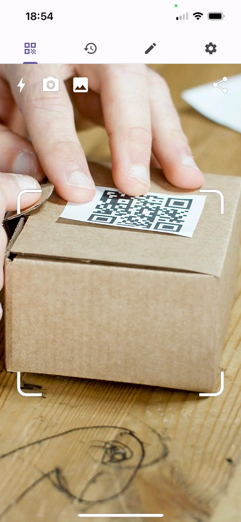 QR Code Scanner - Smart Scan - A mobile application interface scanning a QR code on a small cardboard package