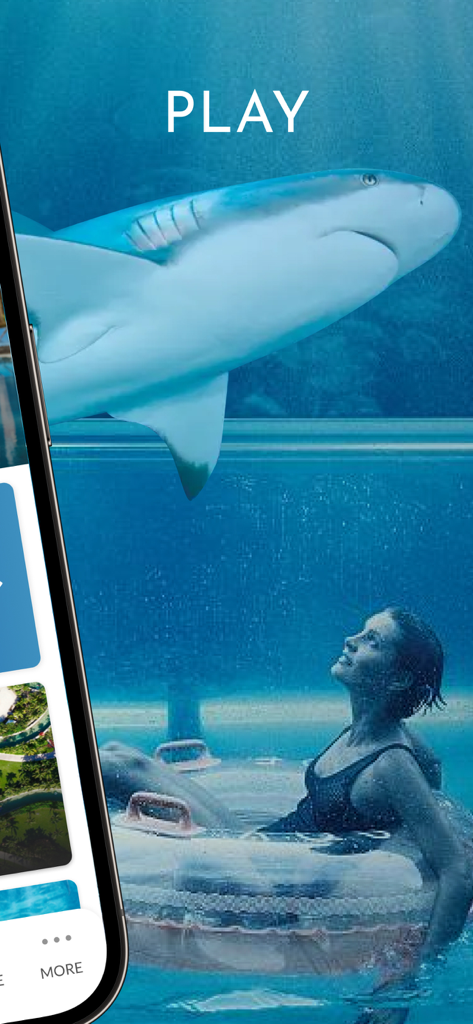 Atlantis Bahamas - アトランティス・バハマの透明な水族館の壁越しに泳ぐサメを見ている、プールチューブに乗ったゲスト。