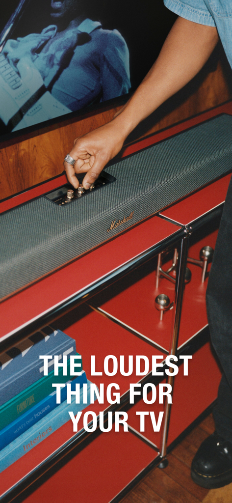 A person adjusting the control knobs on a Marshall Heston soundbar placed on a modern red shelf