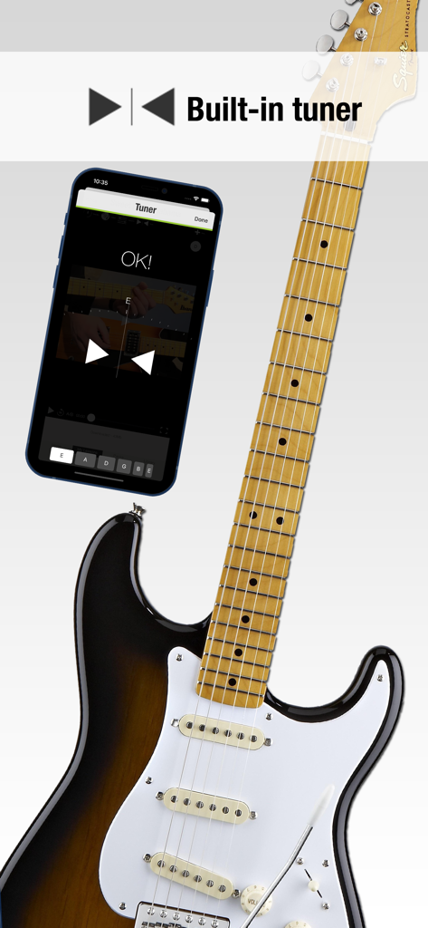 Guitar Masterclass - L'interfaccia dell'accordatore integrato dell'app Guitar Masterclass su un iPhone accanto a una chitarra elettrica