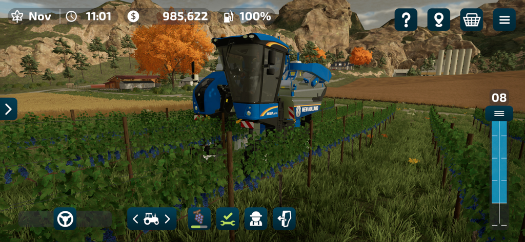 Farming Simulator 23 Mobile - A blue New Holland grape harvester operating in a vineyard in Farming Simulator 23 Mobile