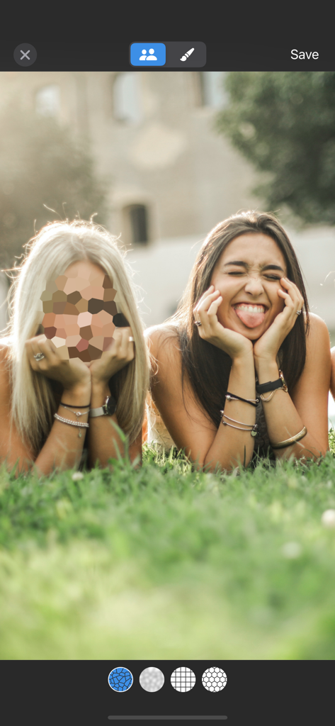 BlurFace - A photo of two women on grass with one face obscured by a mosaic pixelation filter in the BlurFace app