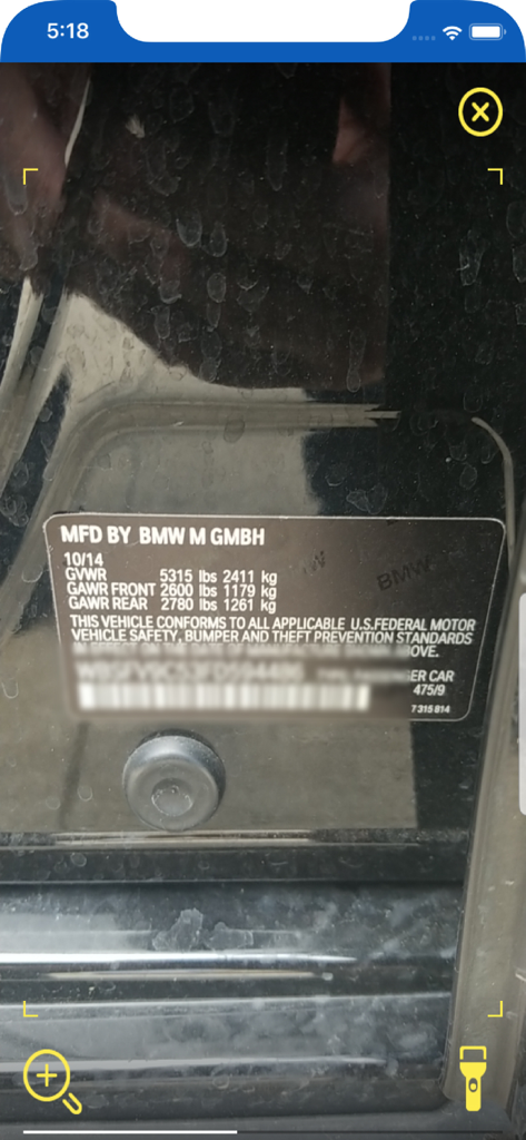 A mobile interface using the Copart GO app to scan a BMW manufacturer plate for VIN decoding