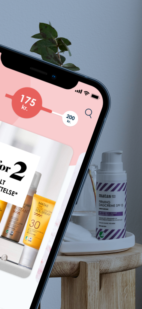 Club Matas - マタスのフェイスクリームの物理的なボトルの隣にある、クラブマタスアプリのロイヤルティポイント進捗バーを示すスマートフォン。