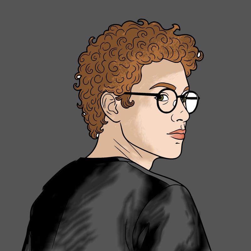 trans man with curly hair and glasses