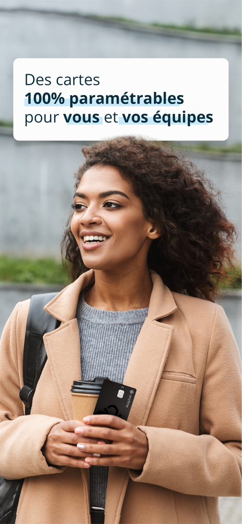 A smiling professional woman holding an Anytime business Mastercard and a coffee cup.