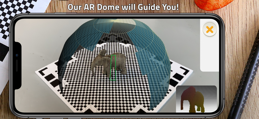 Smartphone screen showing the Qlone 3D scanner app using its AR dome to guide the scanning of a small elephant figurine on a checkered mat