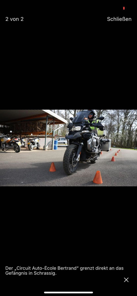 Wort E-Paper - Motorradfahrer navigiert durch orangefarbene Pylonen auf einem Fahrübungsparcours.