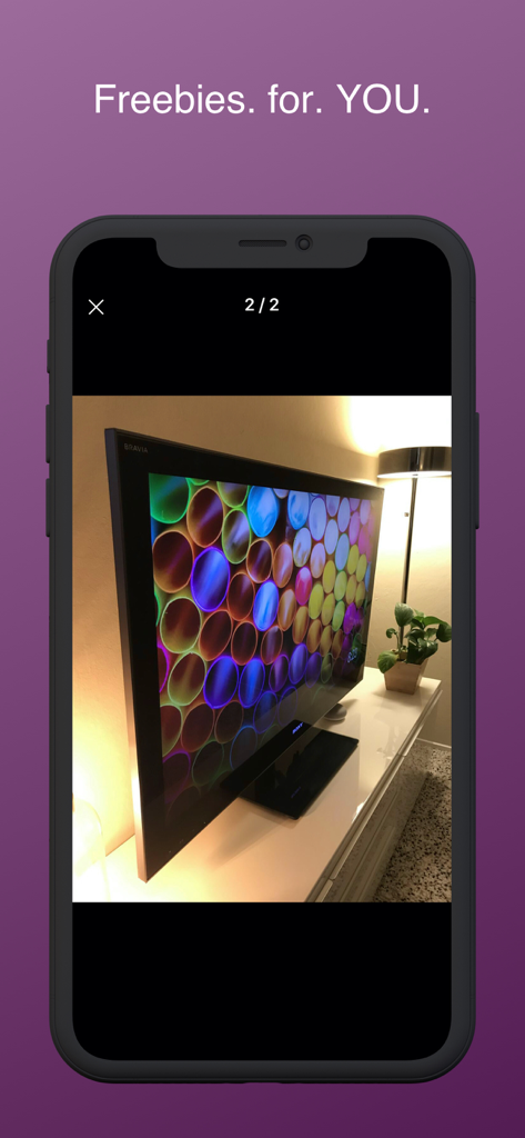 A smartphone showing a free flat screen TV listing on the Freebie Alerts app
