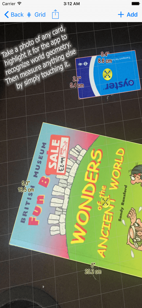 Aplicación Photo Meter midiendo un libro usando una tarjeta de referencia como escala sobre una superficie cuadriculada