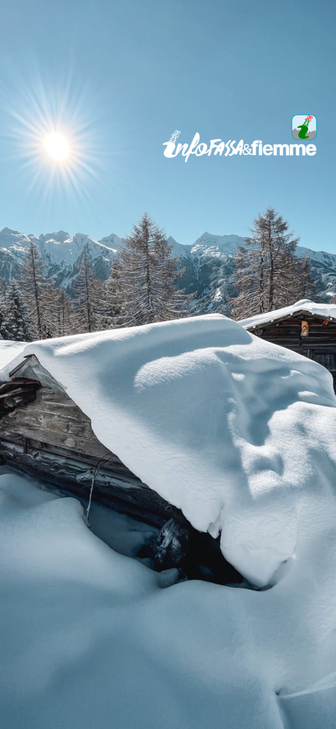 Snow covered mountain cabin in the Dolomites under a bright sun