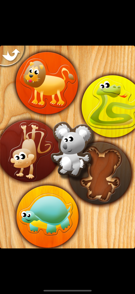 My First Puzzles - Niño pequeño emparejando piezas de puzles de animales de dibujos animados sobre un fondo de madera.