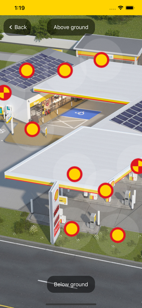 Modelo 3D interactivo de una estación de servicio Shell mostrando marcadores de estándares de diseño para infraestructura sobre el suelo.