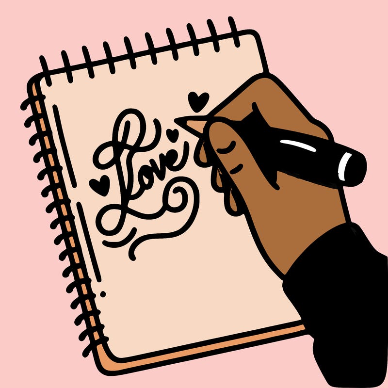 a hand writing “love” in calligraphy on a notebook
