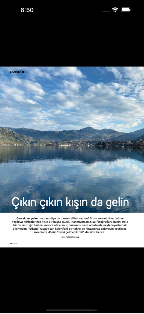 Naviga Magazine - A scenic view of a calm bay surrounded by mountains from a charter article in Naviga Magazine