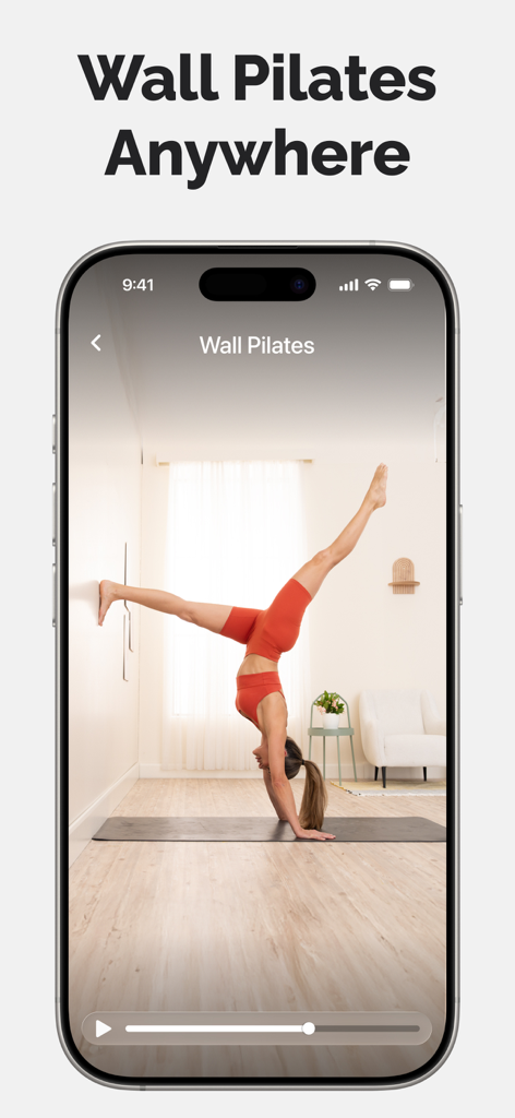 Lotus Flow - Yoga & Workout - A woman practicing wall pilates with a handstand on the Lotus Flow app
