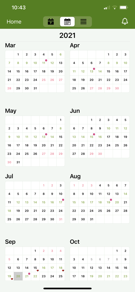Vista de calendario anual en la aplicación Period Tracker que muestra ciclos rastreados y fechas de fertilidad con íconos florales.