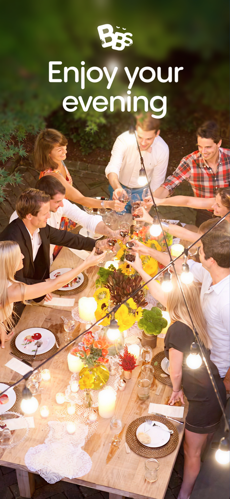Baby Sittor - A group of friends toasting with wine glasses at a beautifully lit outdoor dinner party