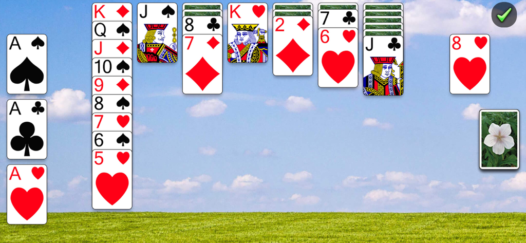 Classic Solitaire Netflix gameplay featuring a blue sky and green field background theme