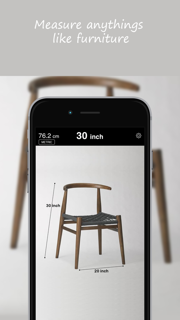 AR定規アプリが、スマートフォンの画面上に木製の椅子の高さと幅の測定値を表示しています。