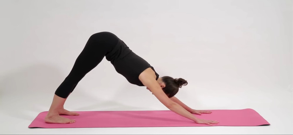 Woman performing the downward facing dog yoga pose