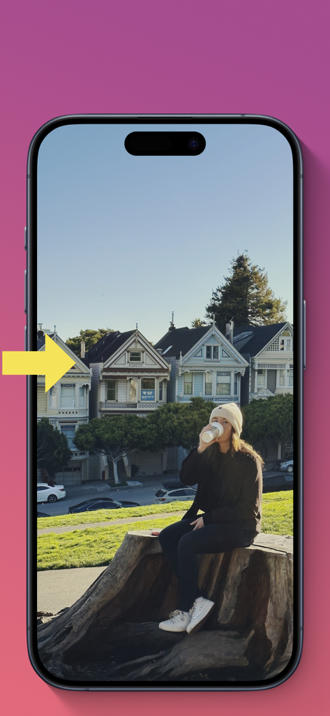 A woman sitting on a tree stump in front of Victorian houses with a yellow arrow indicating the AI photo extension area.