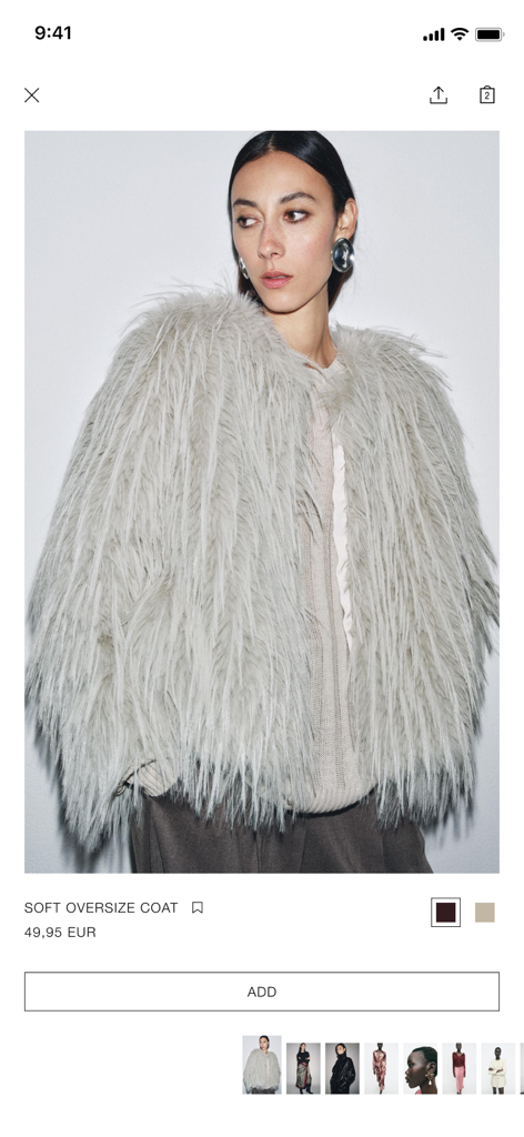 Página de detalles del producto en la aplicación móvil Zara con una modelo luciendo un abrigo oversize de pelo sintético gris con precio y botón de añadir a la cesta.