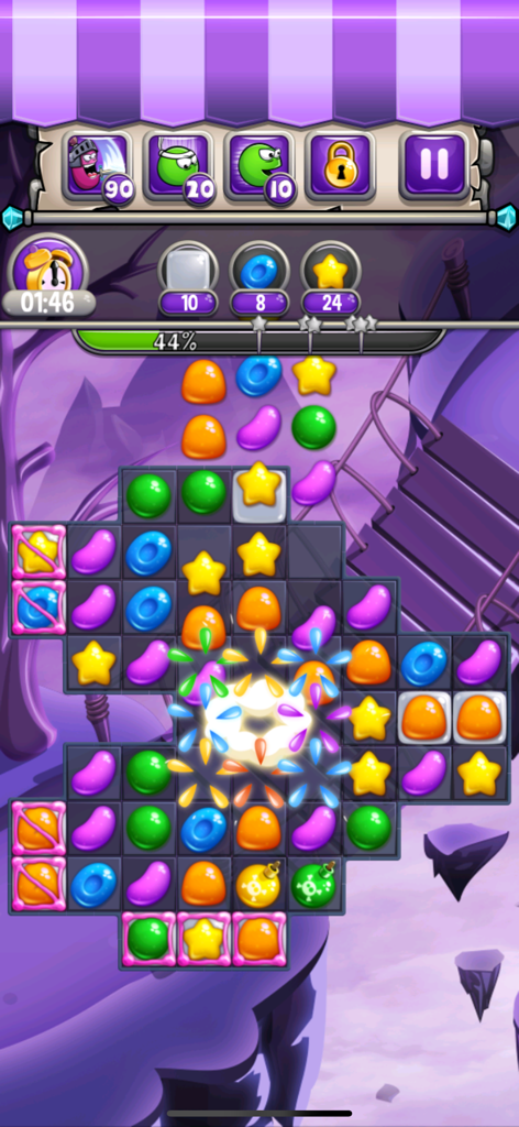 Un nivel de puzzle de combinar 3 en Jewel World Candy Deluxe mostrando coloridas piezas de caramelo y un efecto de explosión central