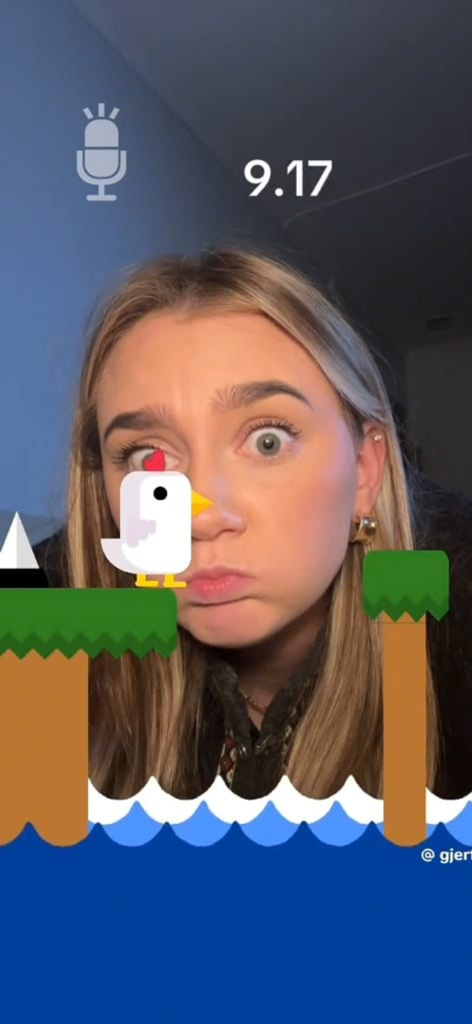 Eine junge Frau spielt Chicken Scream Challenge und benutzt ihre Stimme, um eine Hühnerfigur auf dem Bildschirm zu steuern