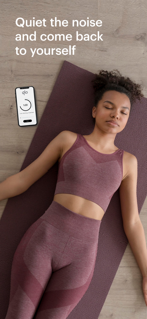 Glo | Yoga and Meditation App - A woman meditating on a mat with the Glo app on her phone
