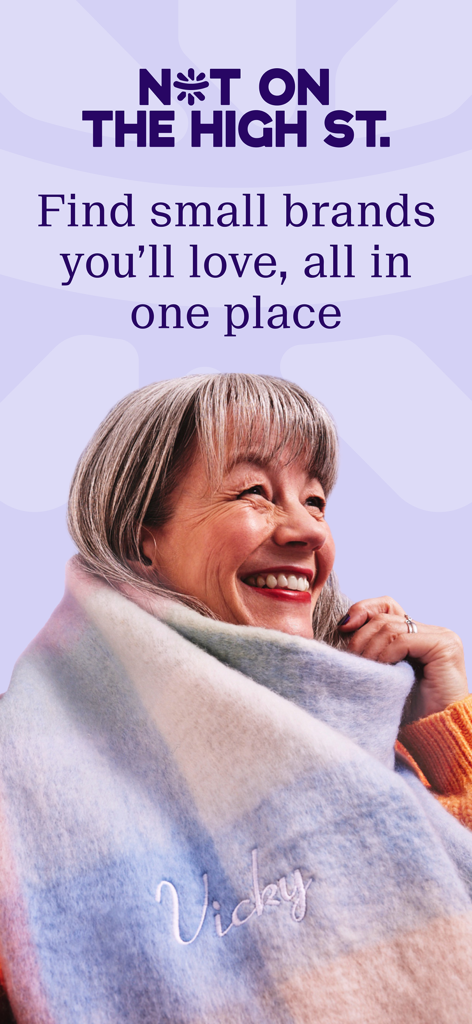 A smiling woman wearing a personalized embroidered scarf from the Not On The High Street marketplace.
