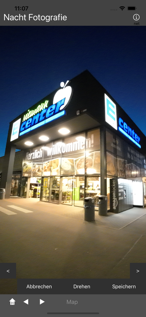 Wide angle night shot of a shopping center exterior in the Night-Photography app interface.