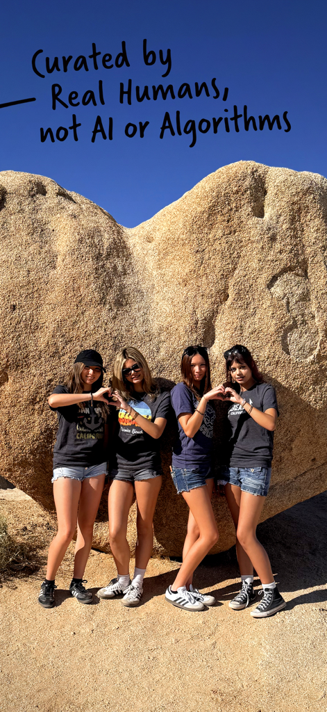 Quatre amis posant devant une formation rocheuse en forme de cœur dans un paysage désertique