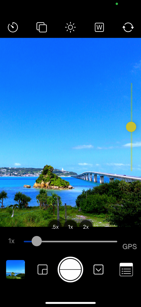 Screenshot of OneCam 2 mobile app interface showing manual exposure and zoom controls while capturing a landscape photo