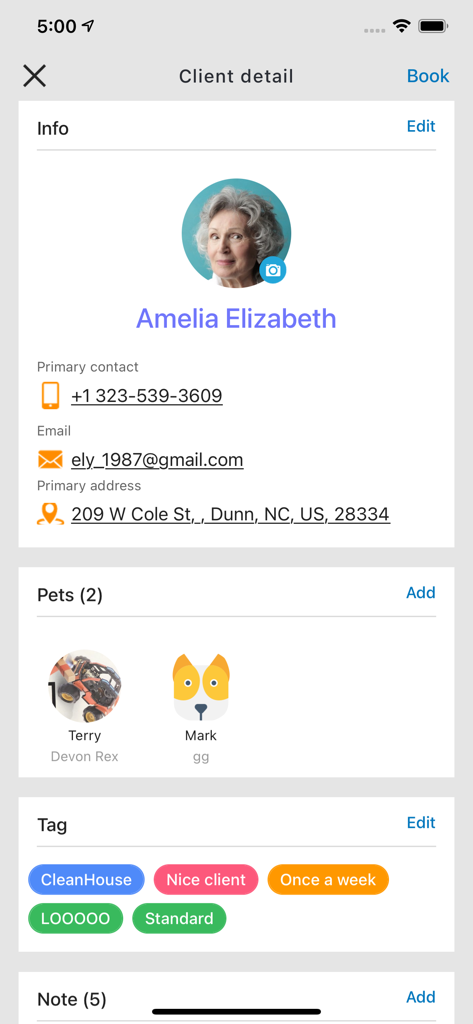 Mobile screen of GrooMore app showing a detailed client profile with contact info pets and custom tags