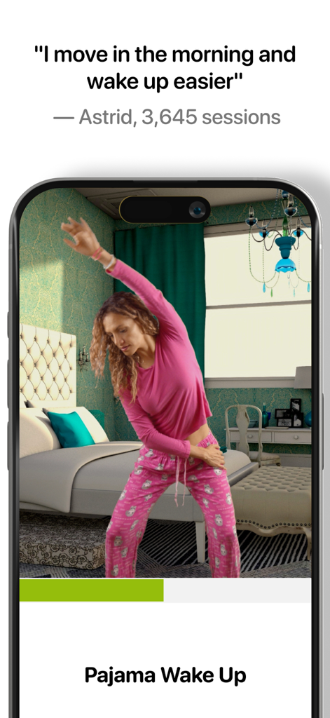 A woman in pink pajamas performing a side stretch in a bedroom using the Wakeout app for a morning wake up routine.