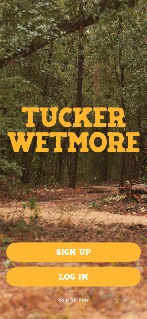 Tucker Wetmore - Tucker Wetmore official music app welcome screen with sign up and log in buttons over a forest background