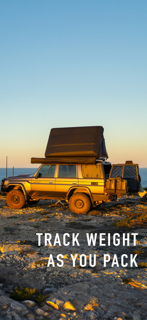 An off-road vehicle with a rooftop tent parked on a rocky coast at sunset