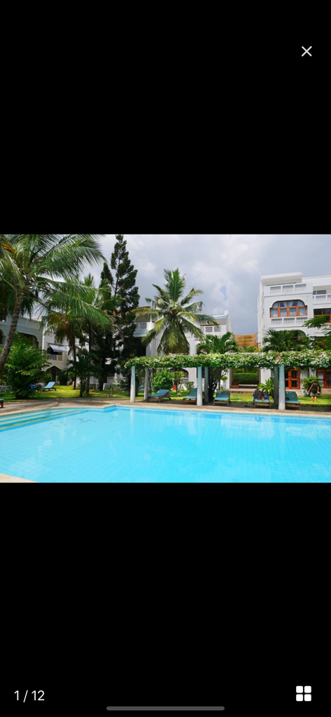 Property24 Kenya - Full screen photo of a luxury apartment complex with a swimming pool and palm trees in Kenya
