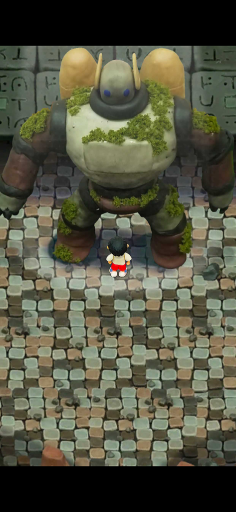 Clay Island - survival games - A tiny character standing before a giant moss covered clay robot on a stone floor in Clay Island